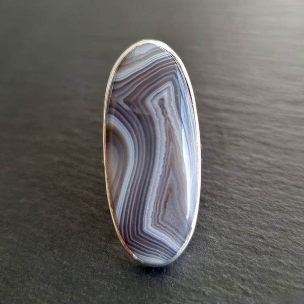 Natural Botswana Agate gemstone displaying elegant grey, white and cream banding with intricate natural patterns.