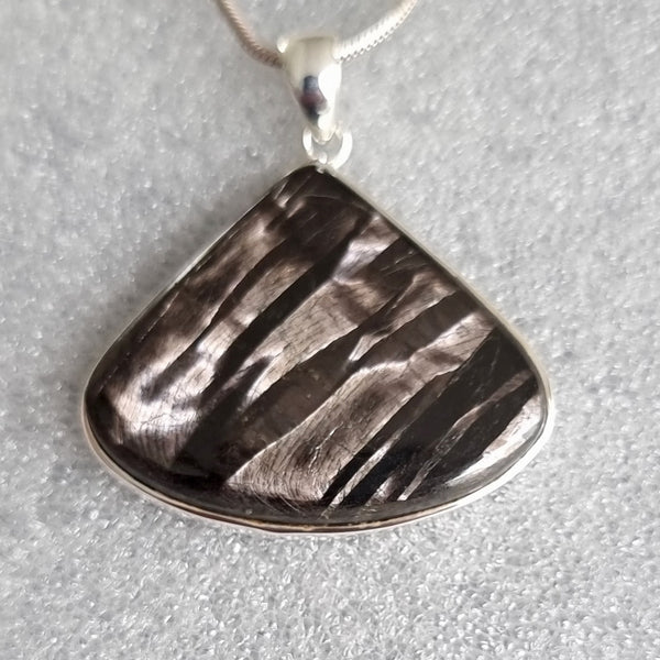 Sterling silver Hypersthene pendant featuring a polished dark charcoal gemstone with a natural bronze and silver shimmer.
