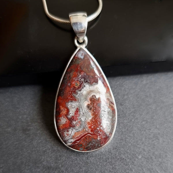 Natural Mexican Lace Agate gemstone displaying intricate cream, beige and brown lace-like banding with a polished finish.