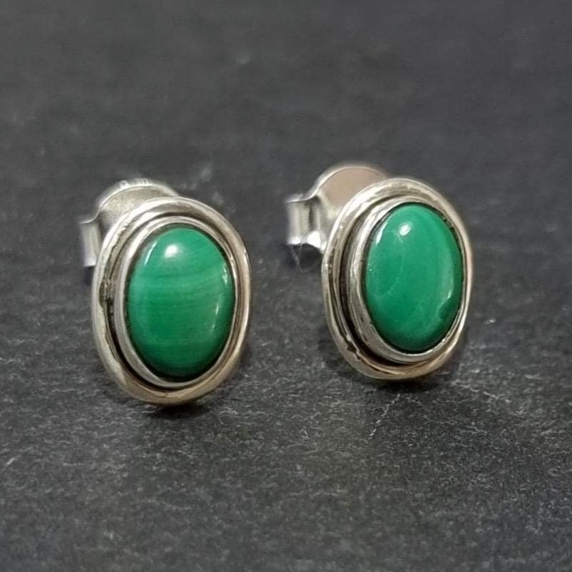 Elegant Oval Cabochon Malachite Stud Earrings in 925 Sterling Silver, featuring a sleek plain silver rim around the patterned dark green gemstone.  Stud size is Height 1.0cm x Width 0.8cm